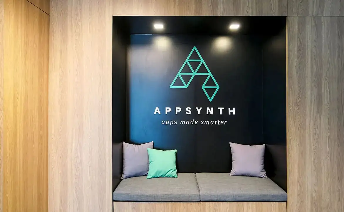 The Appsynth logo on an office wall above a sofa