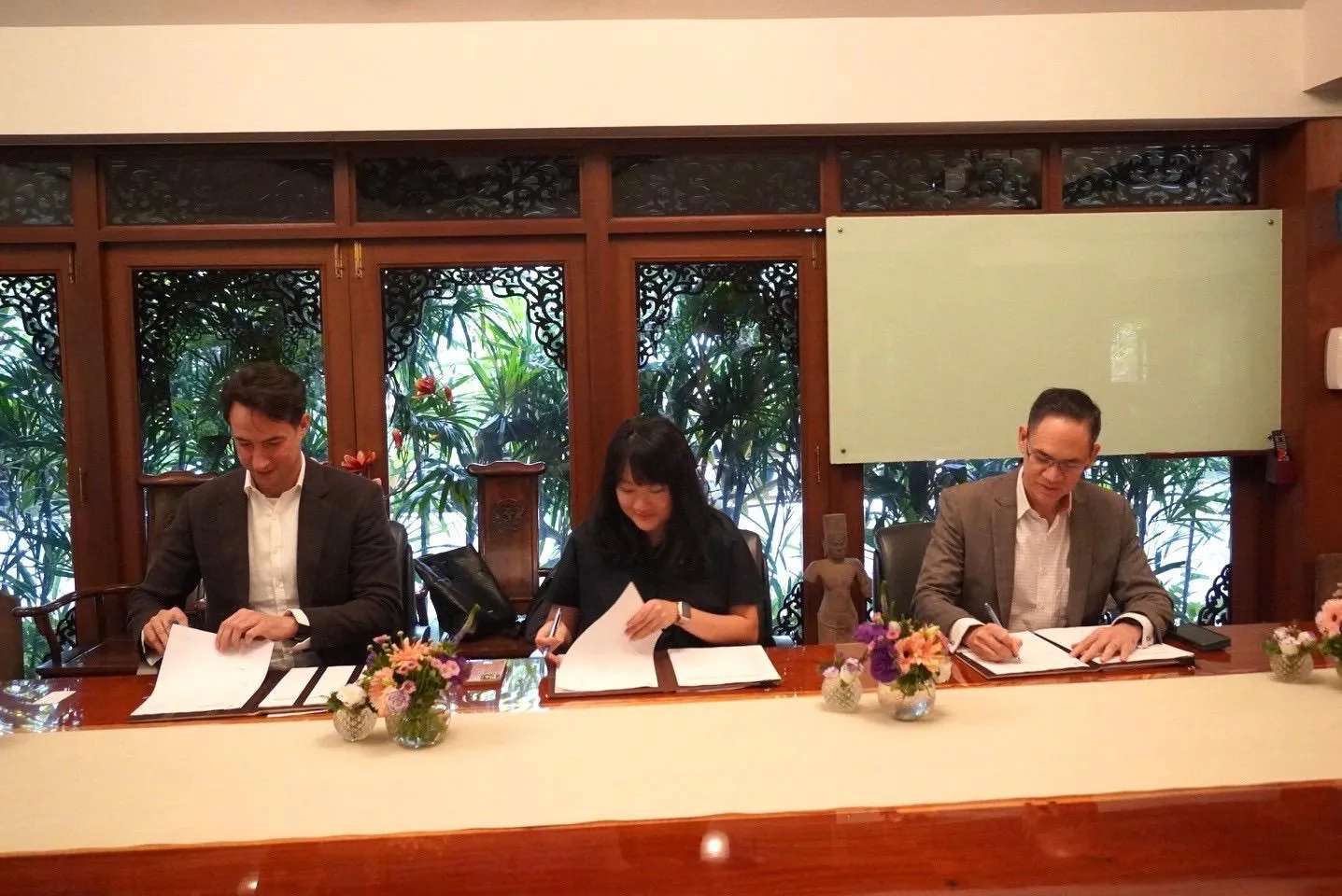 Pawel Michalski, Lena Ng and Nopadej Karnasuta signing the partnership agreement