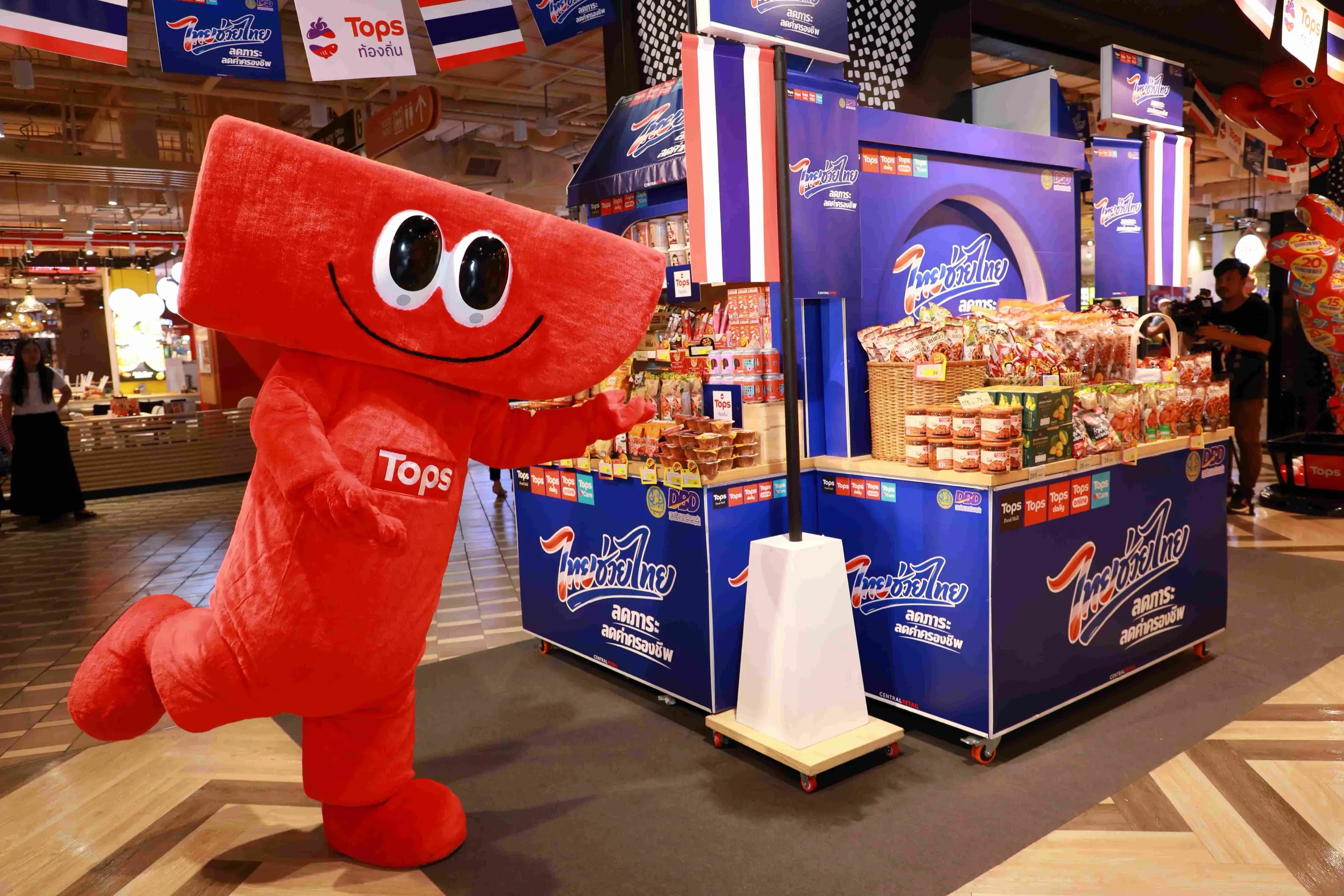 Tops' red mascot beside a local-goods promotion stand in a Tops store