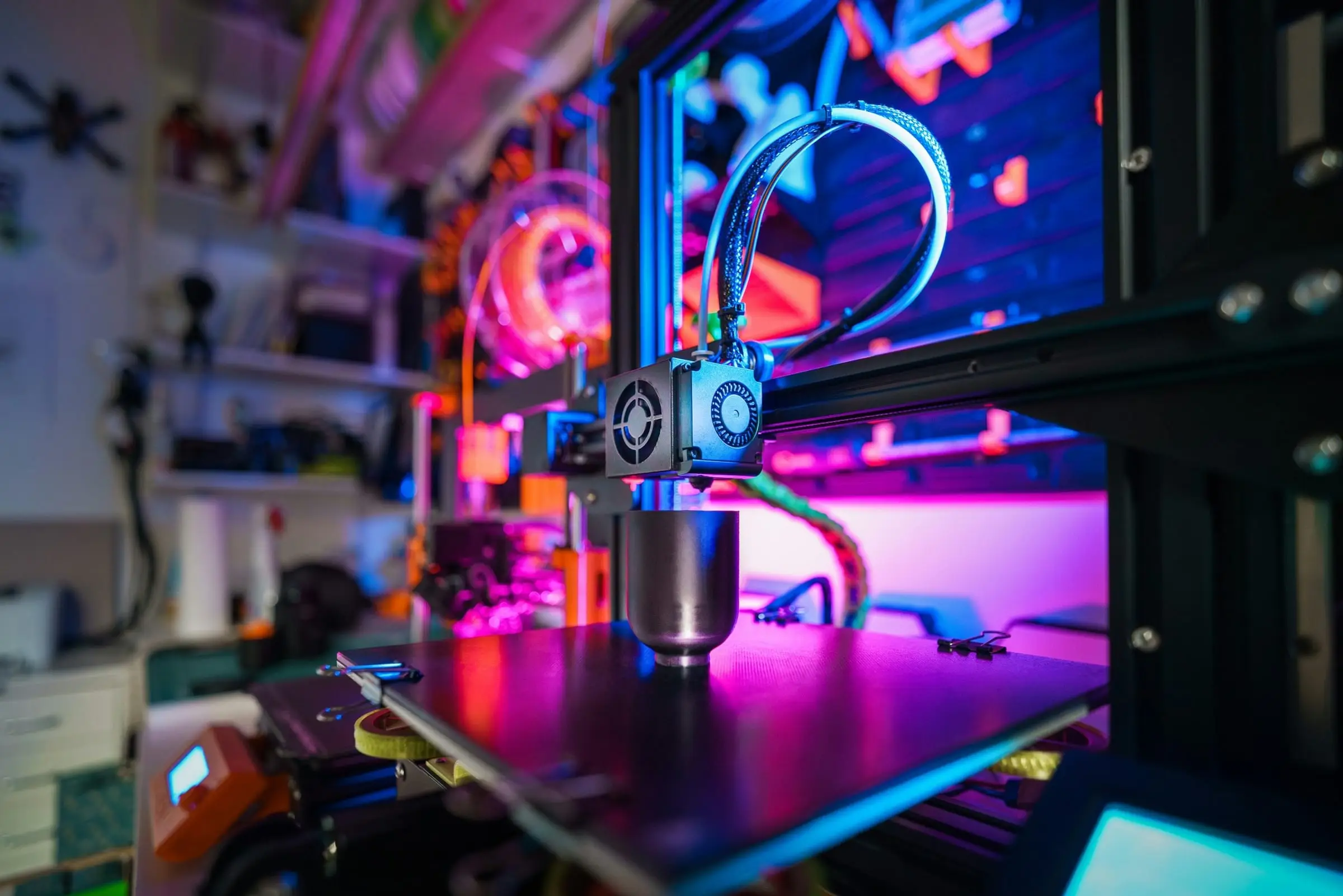 A 3D printer lit in pink and blue